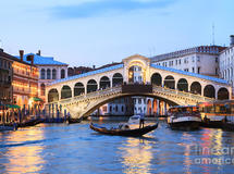 Gondola in front of rialto bridge at dusk venice italy matteo colombo